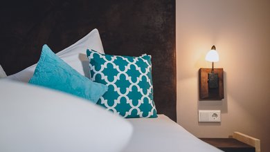 Bett im Apartment Typ B mit eigener Sauna im Margarethenstein 